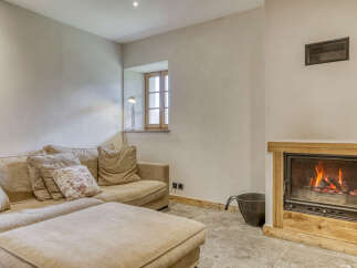 Cozy living room featuring a comfortable sectional sofa with plush cushions and an ottoman, perfect for relaxation.