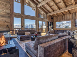 Experience luxurious mountain living in this stunning chalet featuring a grand living room with a roaring fireplace and breathtaking panoramic views of snow-capped peaks.
