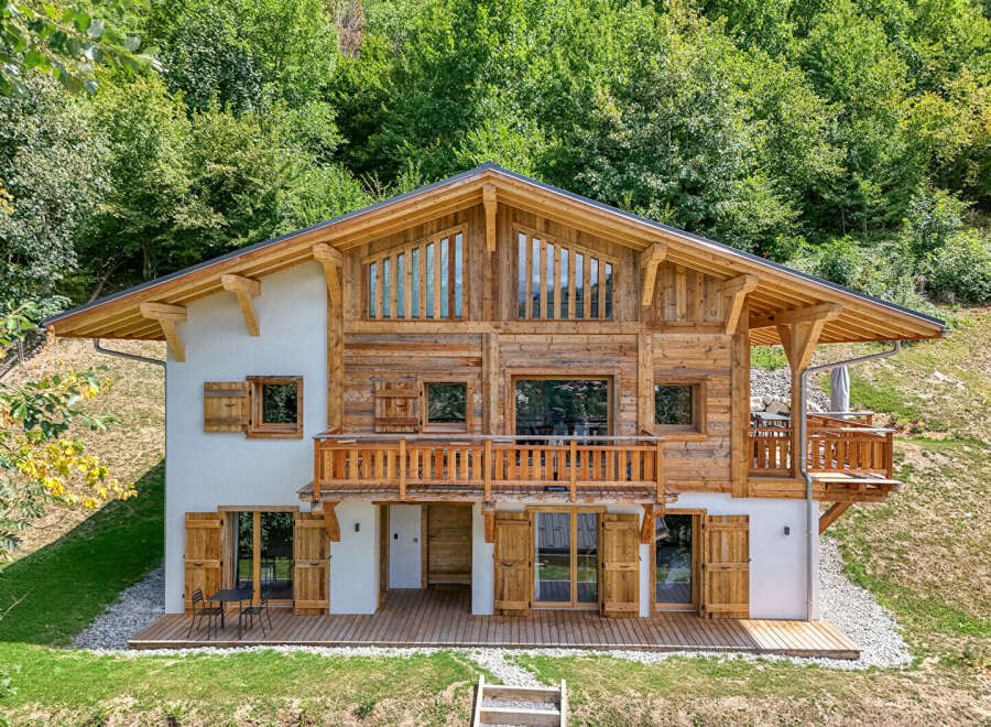 Experience the charm of this stunning wooden chalet nestled in a lush green hillside.