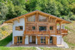 Experience the charm of this stunning wooden chalet nestled in a lush green hillside.