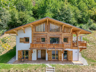 Experience the charm of this stunning wooden chalet nestled in a lush green hillside.