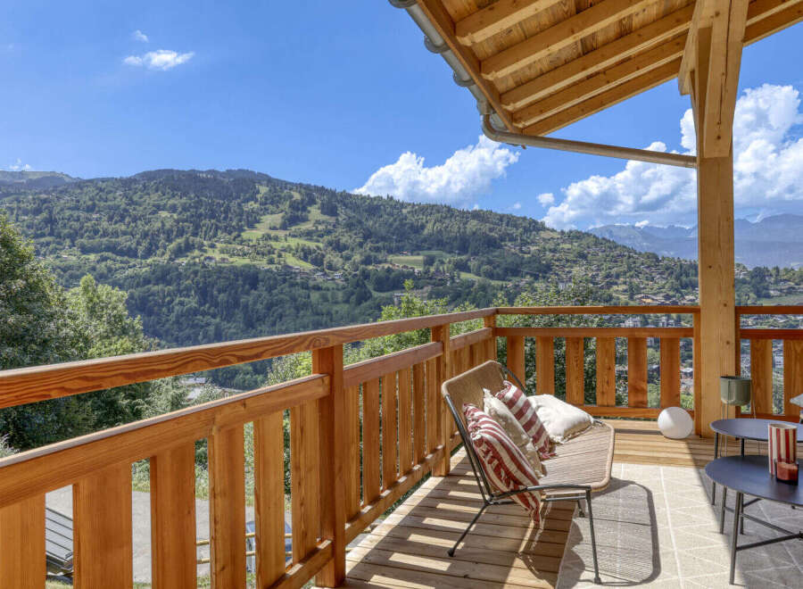 Enjoy breathtaking mountain views from this charming wooden balcony, perfect for relaxing or entertaining.