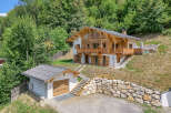 Experience luxury mountain living in this stunning chalet, nestled amidst lush greenery.