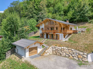 Experience luxury mountain living in this stunning chalet, nestled amidst lush greenery.