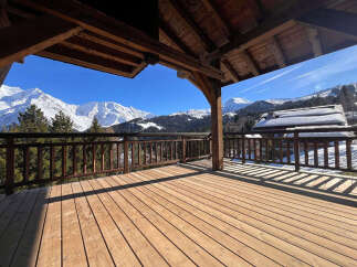 Experience breathtaking mountain views from this stunning wooden deck, perfect for enjoying your morning coffee or evening relaxation.