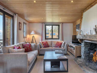 Experience cozy mountain living in this charming living room featuring a rustic stone fireplace and comfortable seating.