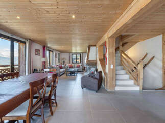 Experience luxurious mountain living in this stunning chalet featuring a spacious open-plan living and dining area with a cozy fireplace.