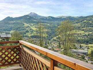Experience breathtaking mountain views from this stunning property, featuring a charming wooden balcony perfect for enjoying the serene landscape.