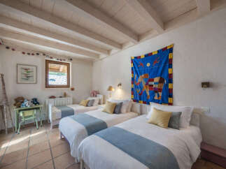 This charming children's bedroom features three twin beds, perfect for accommodating multiple guests or siblings.