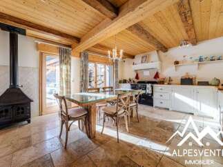 Experience rustic charm in this mountain retreat featuring a cozy dining area with a unique glass-top table and wooden chairs, perfect for gathering after a day of adventure.