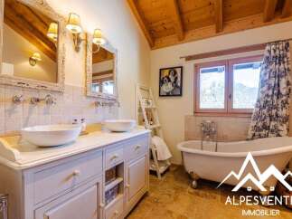 Experience luxury in this charming bathroom featuring a freestanding clawfoot tub and a double vanity with vessel sinks.