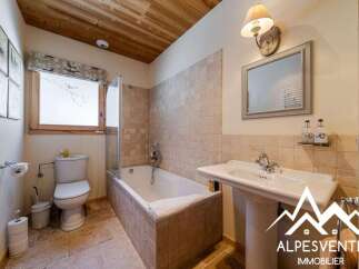 Discover this charming bathroom featuring a classic white bathtub with a glass shower screen, perfect for relaxing after a long day.