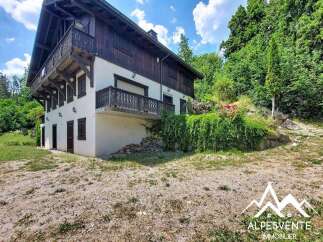 Discover this charming property nestled amidst lush greenery, featuring a traditional wooden chalet with multiple balconies offering picturesque views.