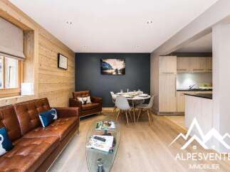 Experience cozy living in this charming mountain retreat, featuring a warm leather sofa and a stylish dining area perfect for gatherings.