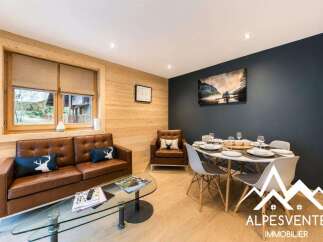 Experience cozy living in this charming mountain retreat, featuring a warm, wood-paneled living area with a comfortable leather sofa and a stylish dining space.