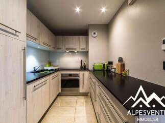 Discover this modern kitchen featuring sleek, light wood cabinetry and a durable black countertop.