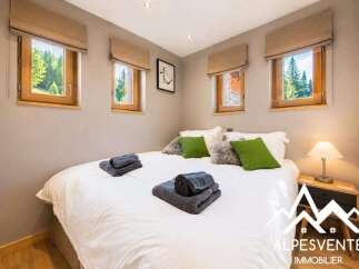 Experience cozy mountain living in this charming bedroom, featuring two inviting windows that offer picturesque views of the surrounding forest.