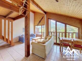 Experience breathtaking mountain views from this charming chalet living area, featuring a cozy seating arrangement and a dining space perfect for family gatherings.