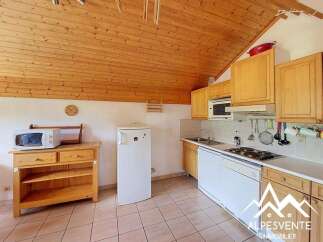 This charming kitchen features warm wooden cabinetry and a vaulted wood-paneled ceiling, creating a cozy atmosphere.