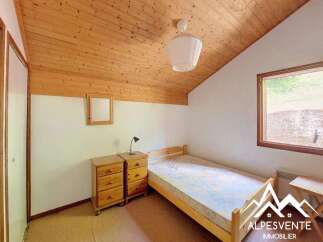Discover this charming bedroom featuring a cozy single bed and two wooden nightstands, perfect for a comfortable stay.