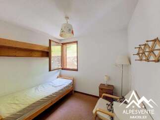 This charming bedroom features a cozy single bed with crisp white linens, perfect for a restful night's sleep.