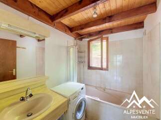 Discover this charming bathroom featuring a practical washing machine and a relaxing bathtub, perfect for unwinding after a long day.