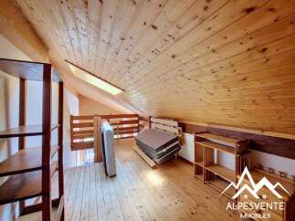 Discover this charming attic space, featuring warm wooden paneling on the walls and ceiling, creating a cozy and rustic ambiance.