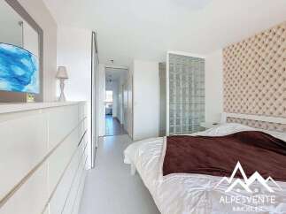 Experience modern living in this beautifully appointed bedroom featuring a plush, tufted headboard and a stylish glass block partition that adds a unique architectural element.