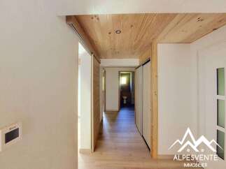 This hallway features a modern design with warm wooden ceilings and sliding doors, creating a sense of spaciousness and natural light.