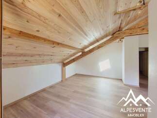 Experience the charm of this attic space featuring a beautifully exposed wooden beam ceiling and light wood flooring.