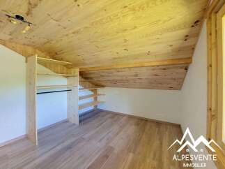 Discover this charming attic room featuring a beautiful natural wood ceiling and flooring, creating a warm and inviting atmosphere.