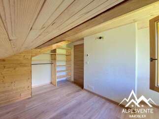 Discover this charming attic room featuring a sloped wooden ceiling and walls, creating a cozy and rustic ambiance.
