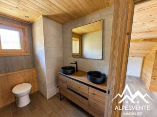 Experience modern mountain living in this beautifully appointed bathroom, featuring a sleek wooden vanity with double vessel sinks and a minimalist faucet.
