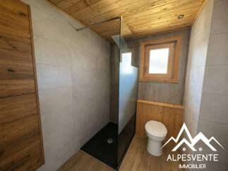 Experience modern mountain living in this stylish bathroom featuring a sleek glass-enclosed shower and a comfortable toilet.