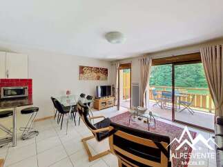 Enjoy stunning mountain views from this charming apartment, featuring a spacious living area with a dining table and a modern kitchen.