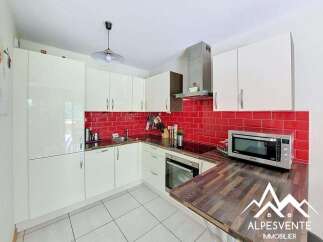 This modern kitchen features sleek white cabinetry and a vibrant red subway tile backsplash, creating a stylish and functional space.