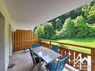 Enjoy your morning coffee on this charming balcony overlooking a lush green forest.