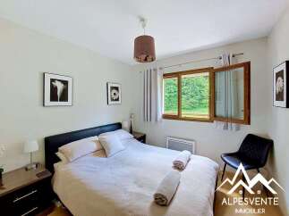 This charming bedroom features a comfortable queen-size bed with plush linens and decorative pillows, perfect for a restful night's sleep.