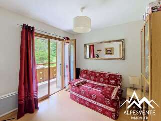 This charming room features a comfortable red sofa adorned with heart patterns, perfect for relaxing.