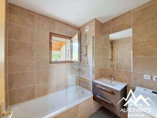 This modern bathroom features a spacious bathtub with a glass enclosure and a sleek vanity with ample storage.