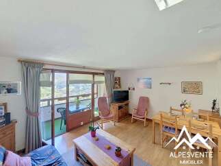 Experience breathtaking mountain views from this charming living space, featuring a cozy seating area and a dining table perfect for family meals.