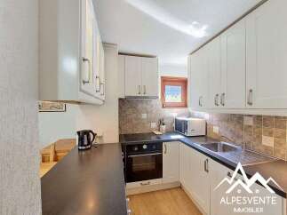 Discover this charming kitchen featuring white cabinetry and a sleek dark countertop.
