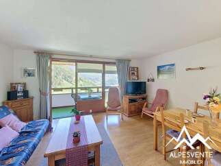 Experience breathtaking mountain views from this charming living space, featuring a comfortable sofa and a dining area perfect for family meals.