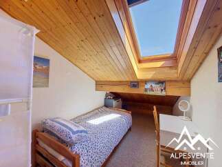 Discover this charming attic bedroom featuring a cozy single bed with a patterned duvet and pillow, perfect for a peaceful retreat.