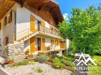 Charming alpine property featuring a multi-level home with traditional wooden accents and shutters.