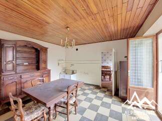 This charming dining room features a rustic wooden hutch and a large wooden table, perfect for family gatherings.