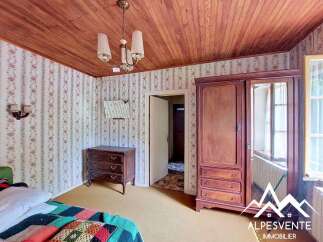 Discover this charming bedroom featuring a vintage wooden wardrobe with mirrored doors, perfect for storing your belongings.