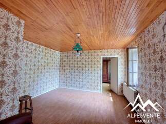Step into this charming room featuring a warm wooden ceiling and walls adorned with a classic floral wallpaper.
