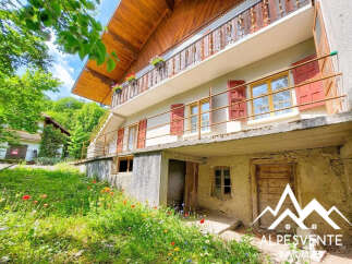 Discover this charming property nestled amidst lush greenery and vibrant wildflowers, offering a serene mountain escape.