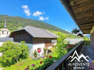 Experience breathtaking mountain views from this charming property, featuring a traditional wooden chalet and a picturesque village setting.